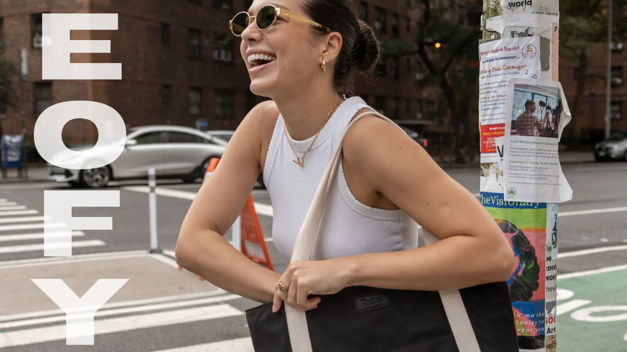 Professional woman holding a tote work bag with bold 'EOFY' overlay text for end-of-financial-year sales.