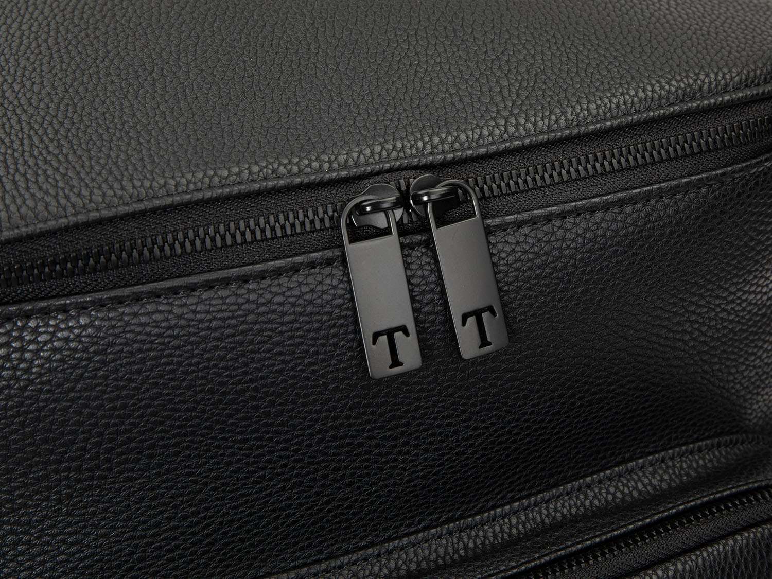 A black leather travel backpack with black zippers