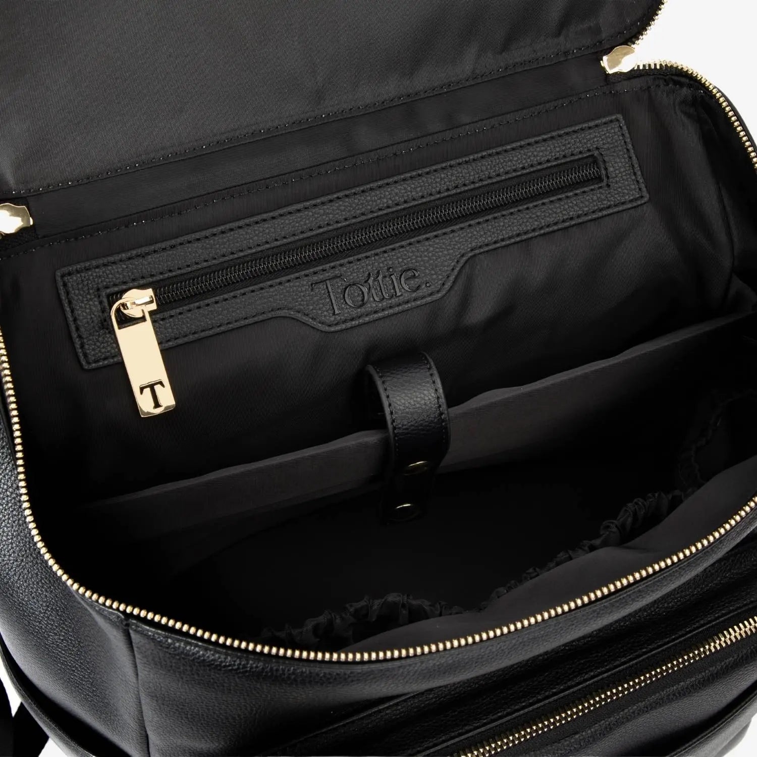 Close-up inside view of black nappy bag backpack featuring gold hardware – spacious and organised interior.