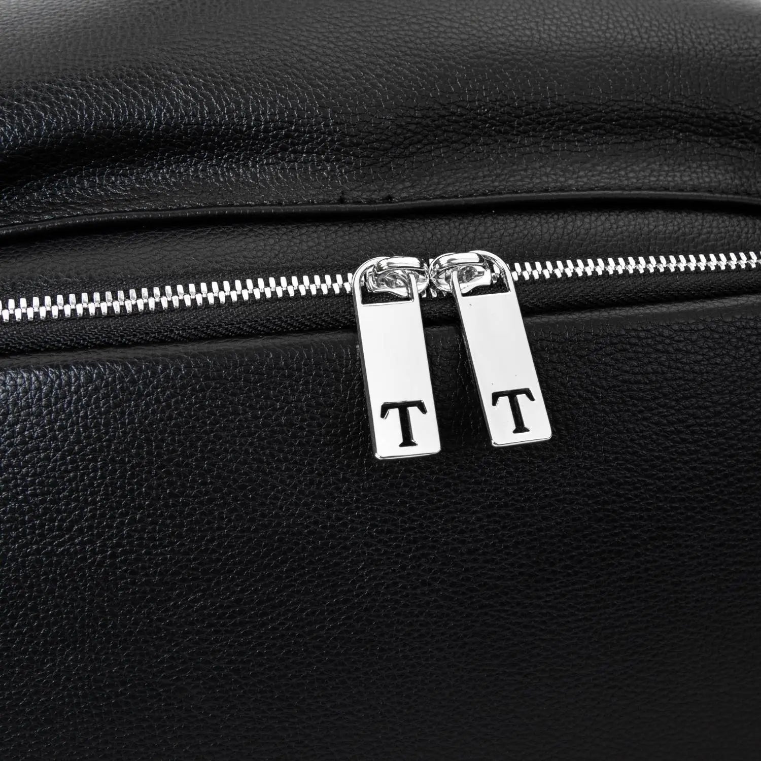 Close-up of silver zipper with letter T on black nappy bag backpack – elegant hardware detail by Tottie.