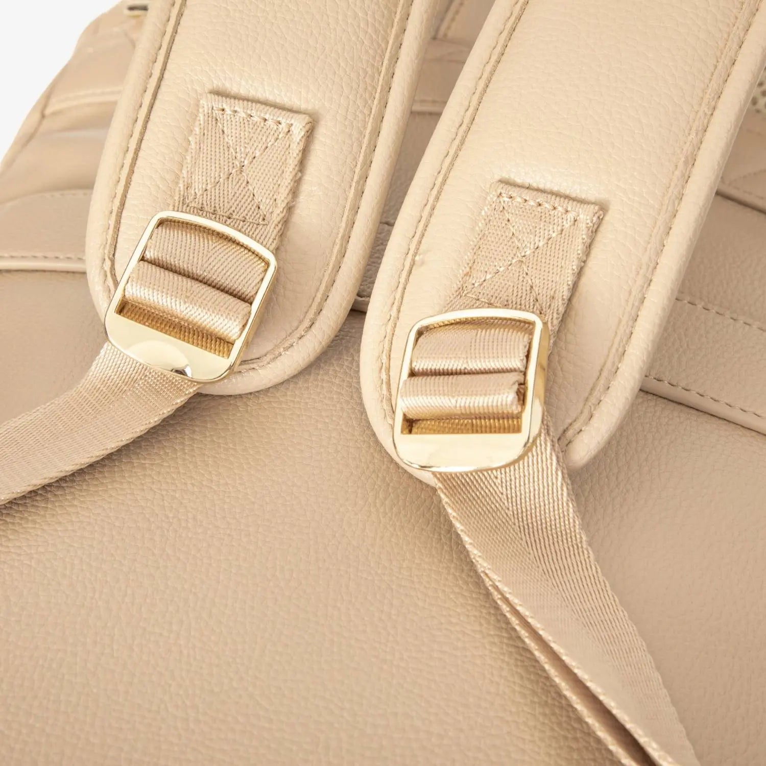 Tan nappy bag backpack strap hardware close-up featuring gold accents – elegant and sturdy design.