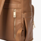 Side view close-up of tan nappy bag backpack zipper with gold hardware – smooth and durable finish.