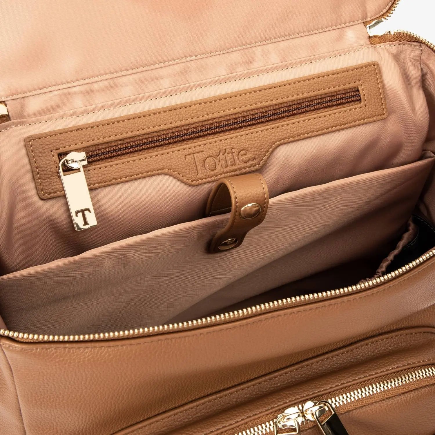 Detailed top open view of tan nappy bag backpack featuring gold hardware – practical design for busy parents.