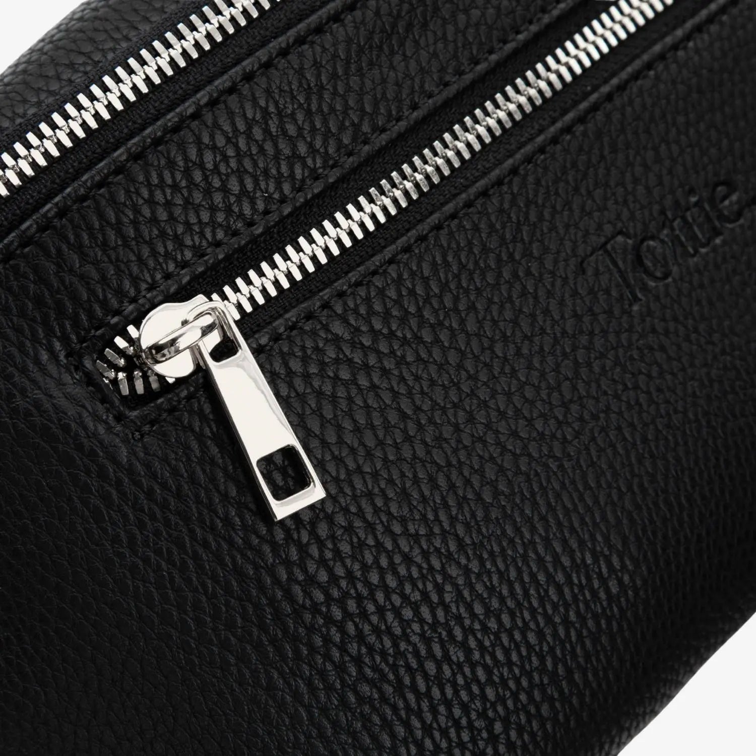Detailed view of black bum bag silver zipper – polished hardware adding a modern touch