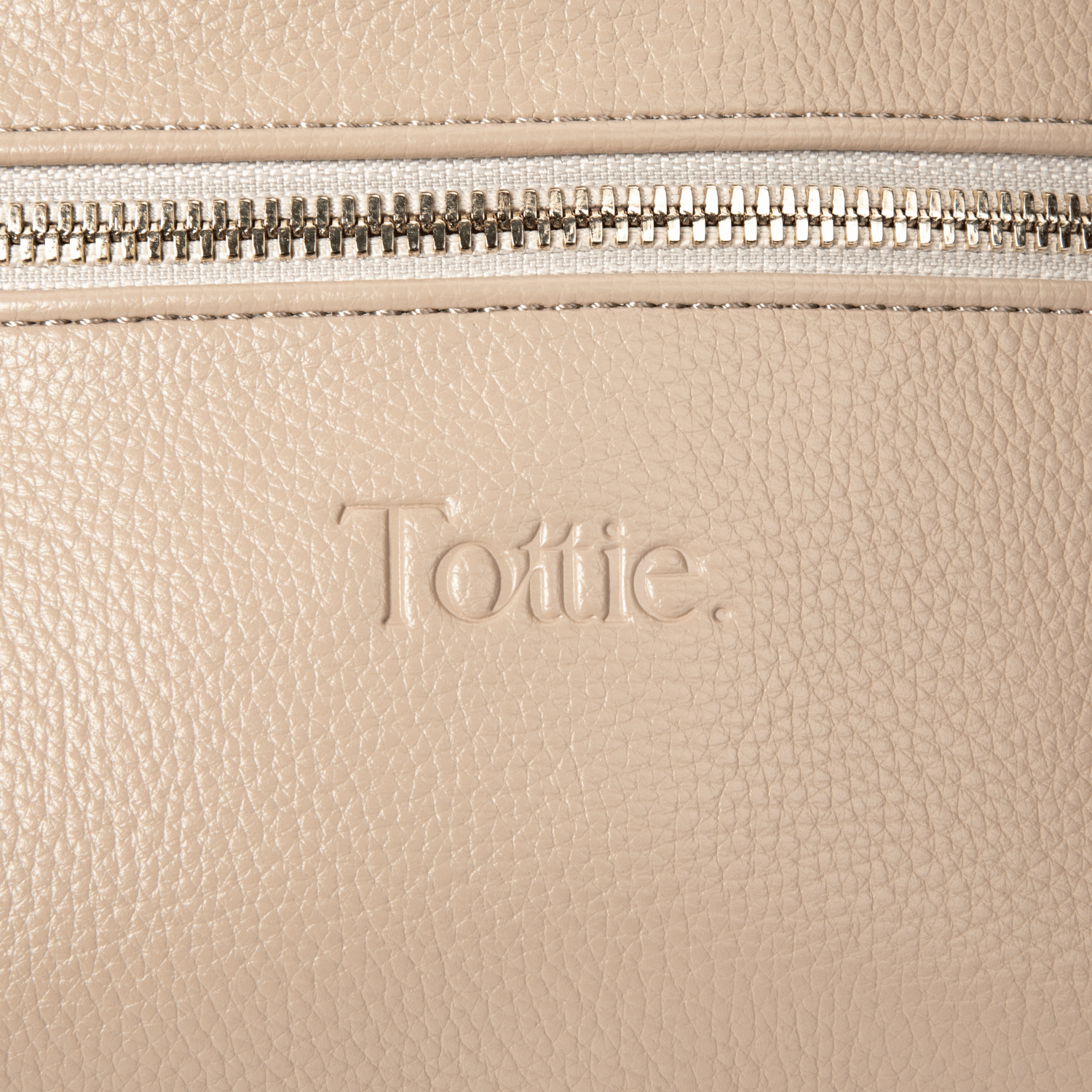 Beige leather bum bag with 'Tottie' branding and a gold zipper.