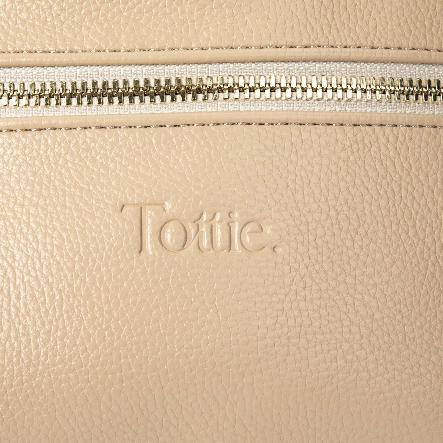 Detailed view of Tottie logo embossing on stone-coloured bum bag with gold hardware – modern and refined finish.
