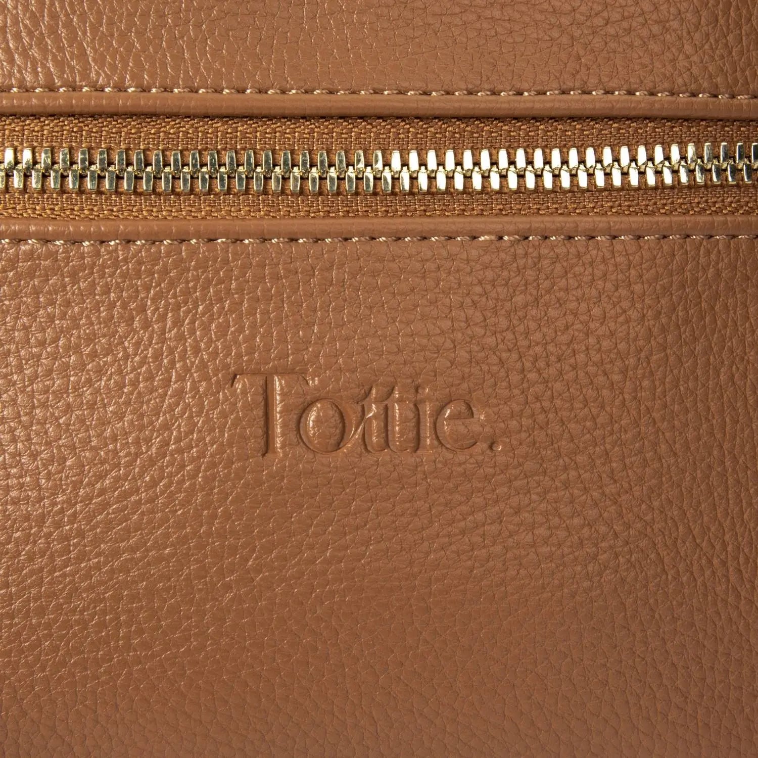 Embossed Tottie branding detail on tan bum bag – close-up shot highlighting quality finish