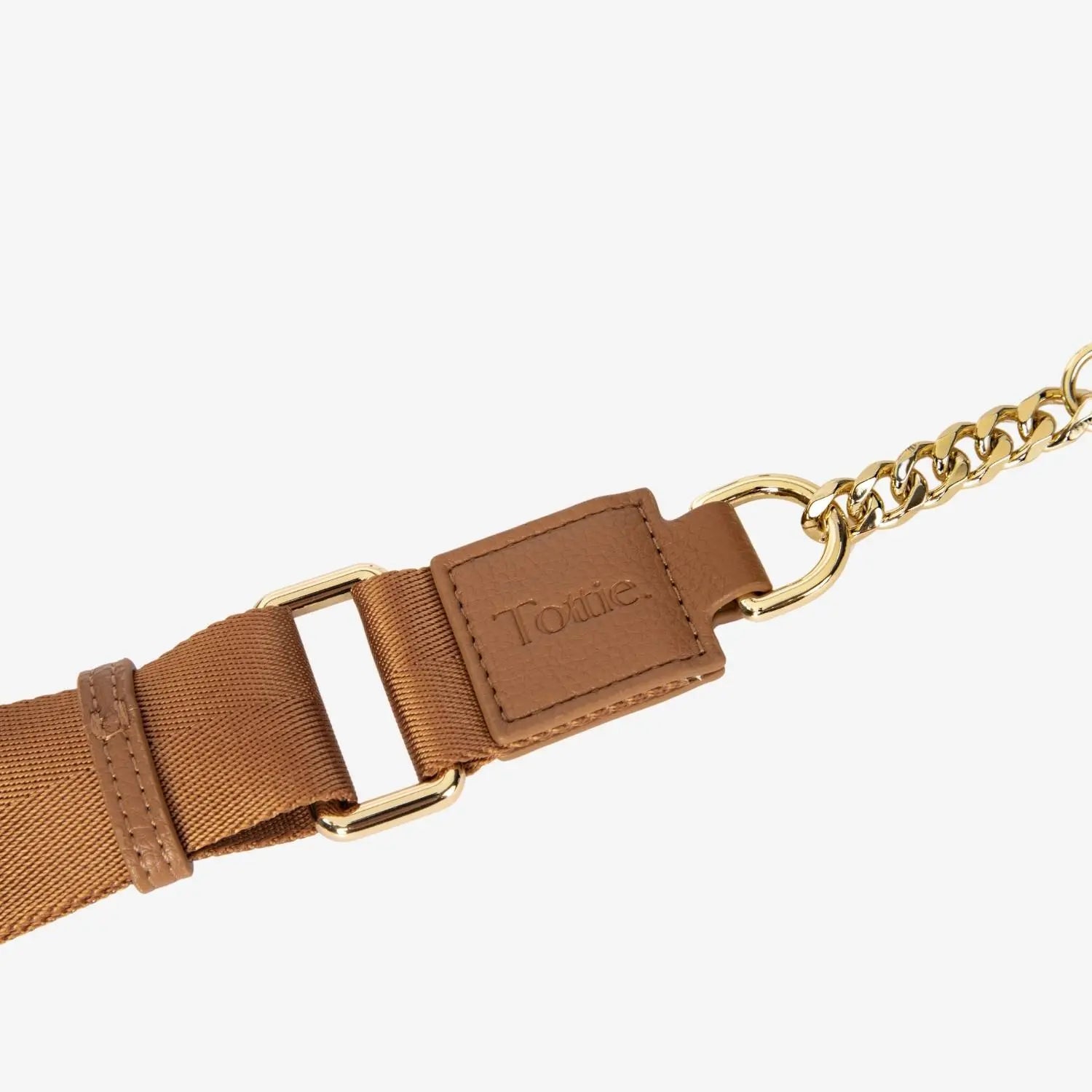 Detailed view of tan bum bag strap featuring embossed Tottie branding and polished gold hardware.