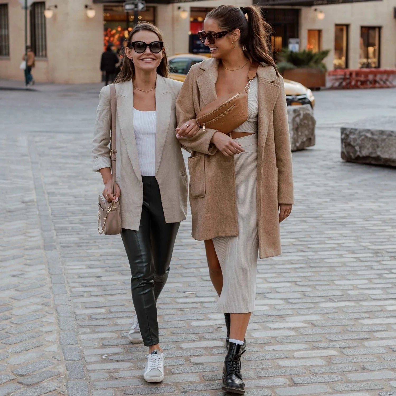 Two fashionable women featuring stone colour crossbody bag and tan bum bag.