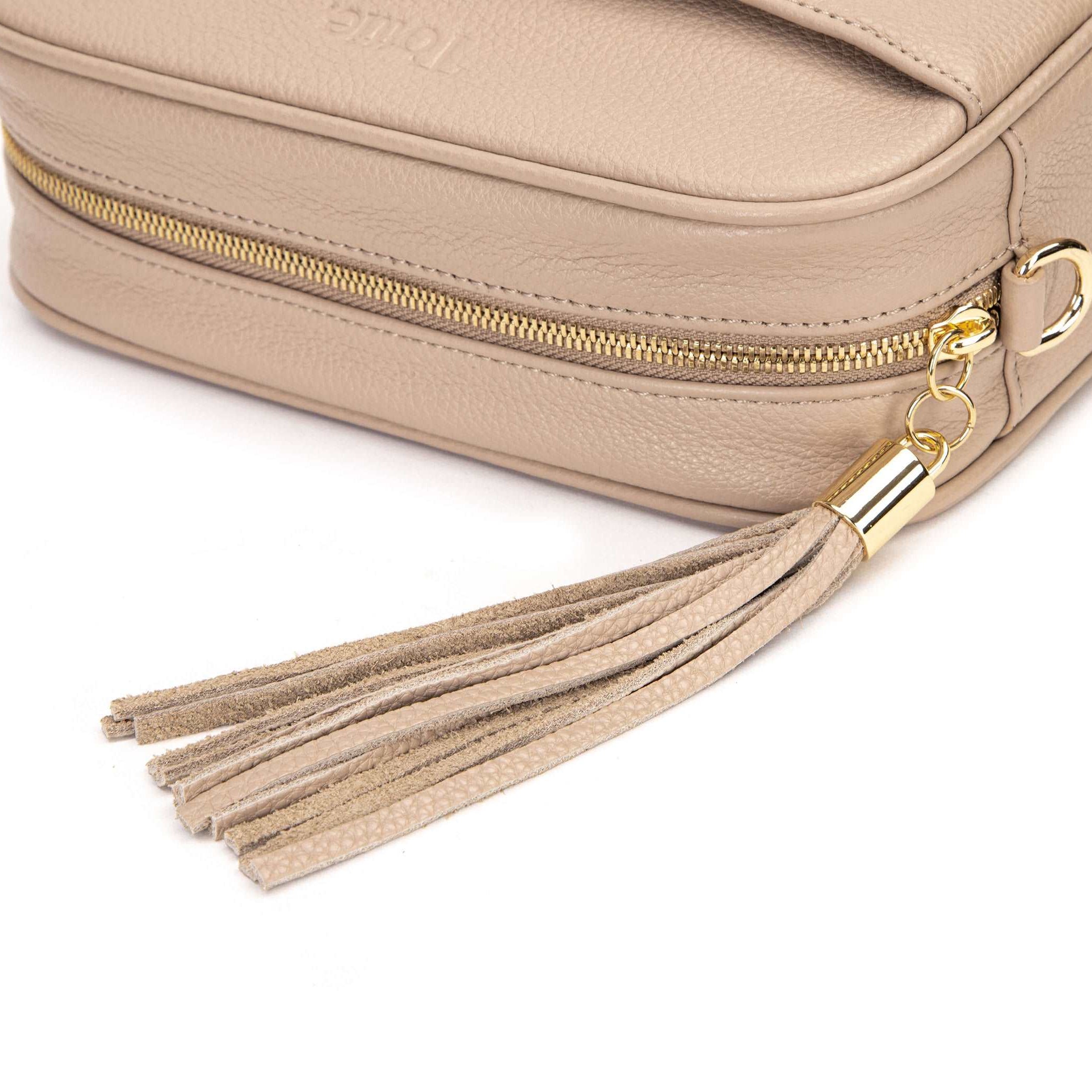stone colored leather crossbody bag in white background