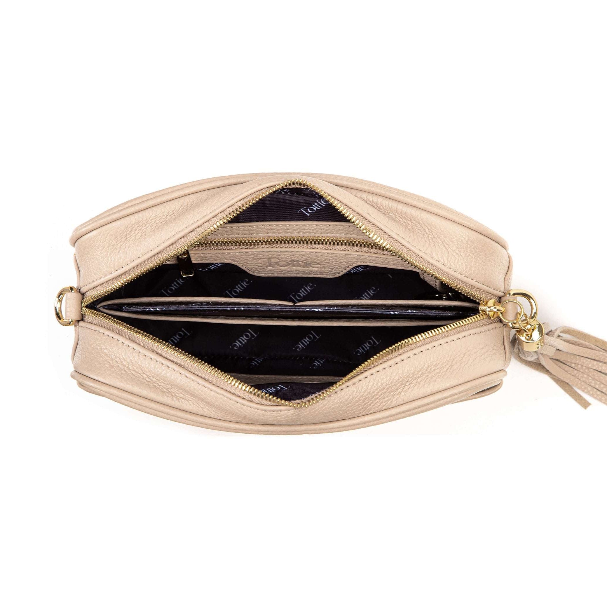 unzipped stone colored leather crossbody bag in white background