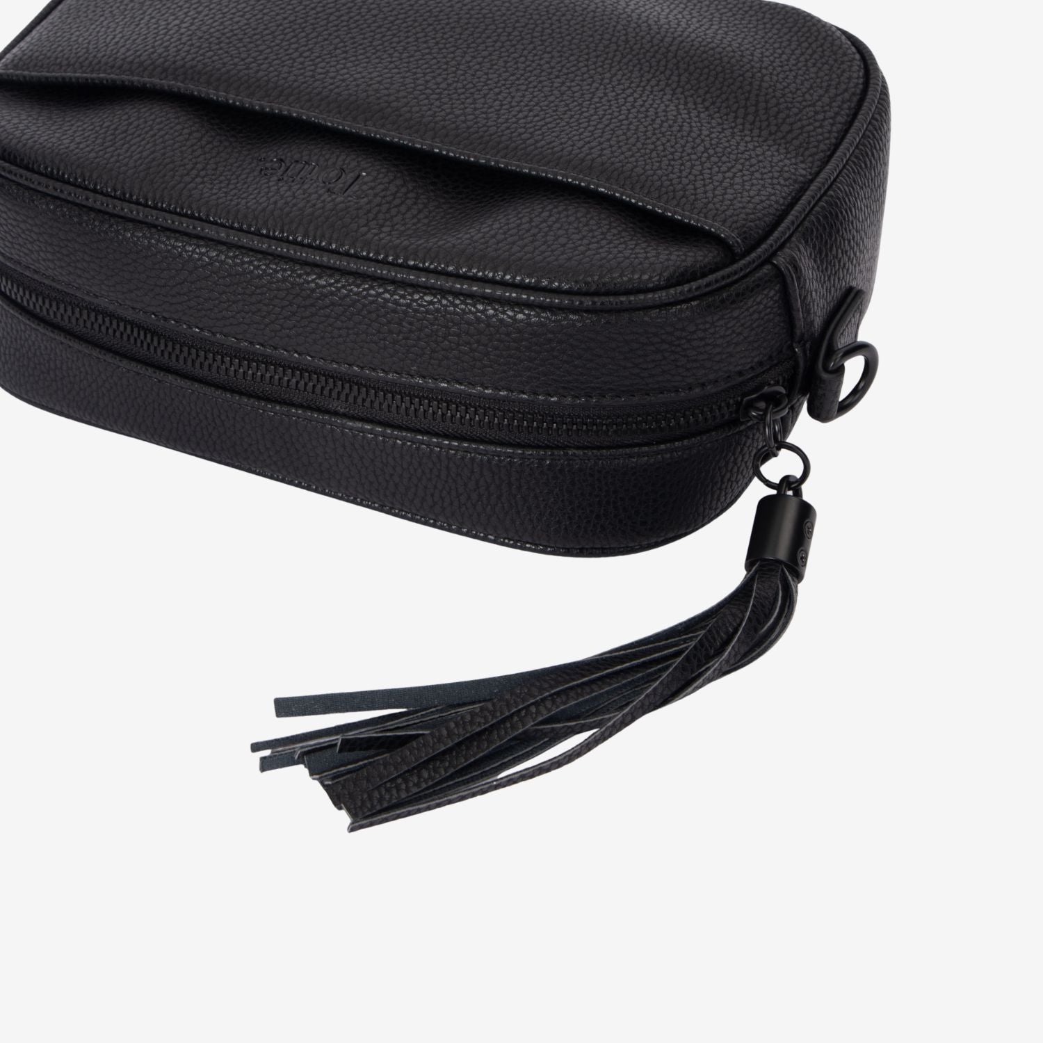 Black leather crossbody bag with a tassel on a white background