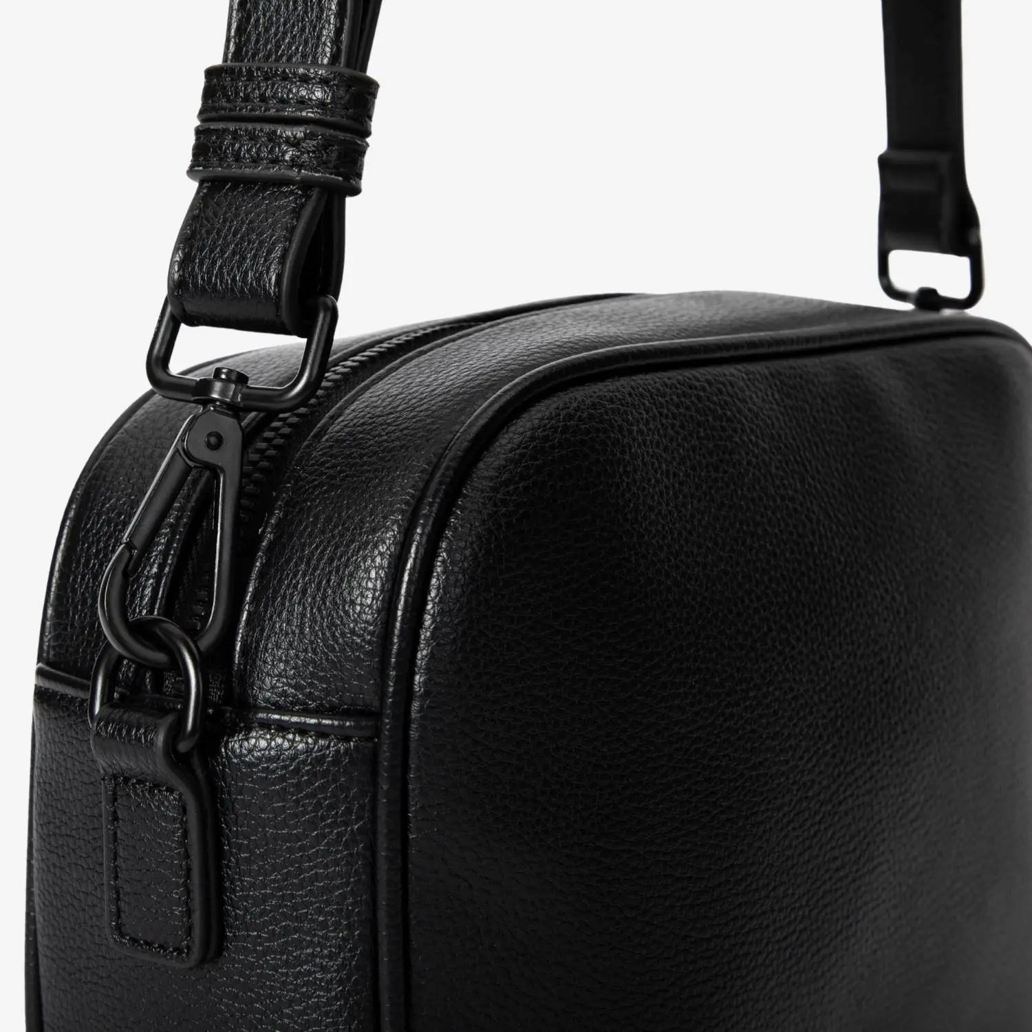Detailed view of black metal hardware on black crossbody bag strap – modern and sturdy design