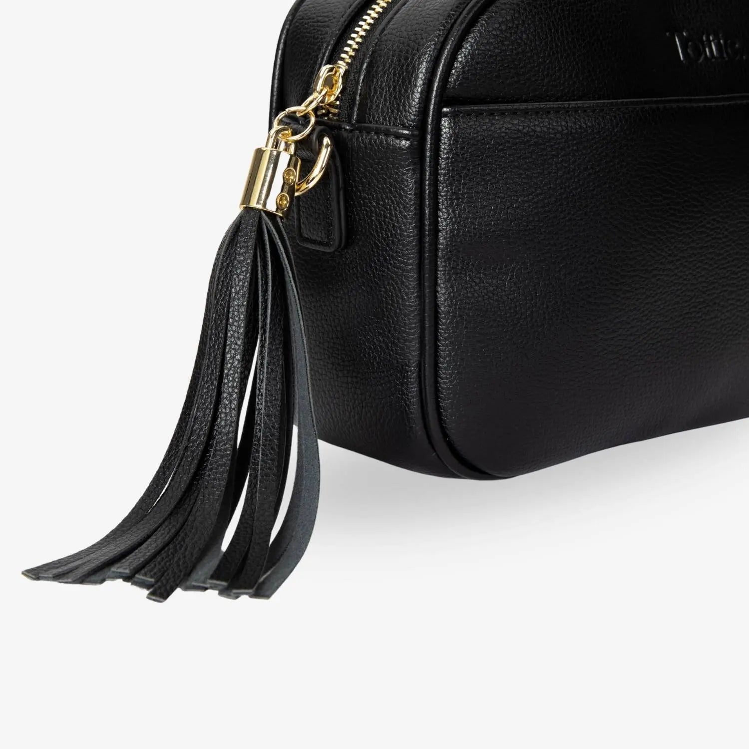 Black crossbody bag tassel close-up featuring gold hardware – stylish and sophisticated detail.