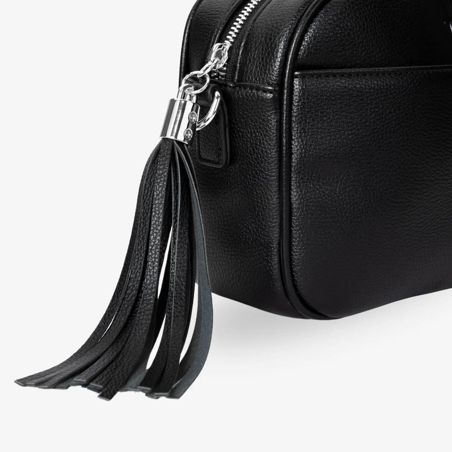 Close-up of black tassel detail on black crossbody bag with silver hardware