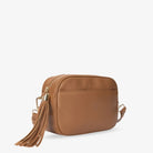 Detailed slight side view of tan colour crossbody bag featuring gold hardware accents