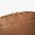 Embossed Tottie logo on front of tan colour crossbody bag with gold hardware