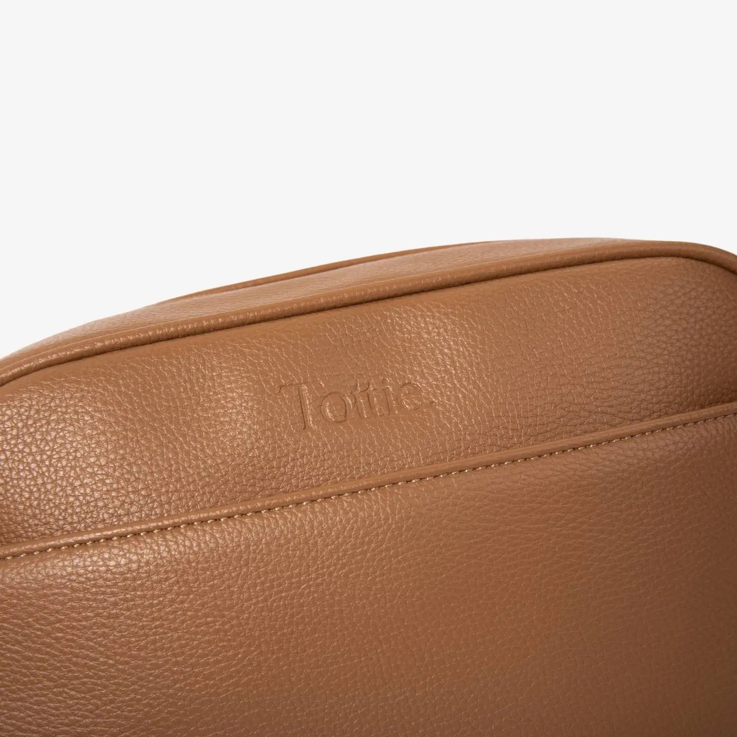 Embossed Tottie logo on front of tan colour crossbody bag with gold hardware