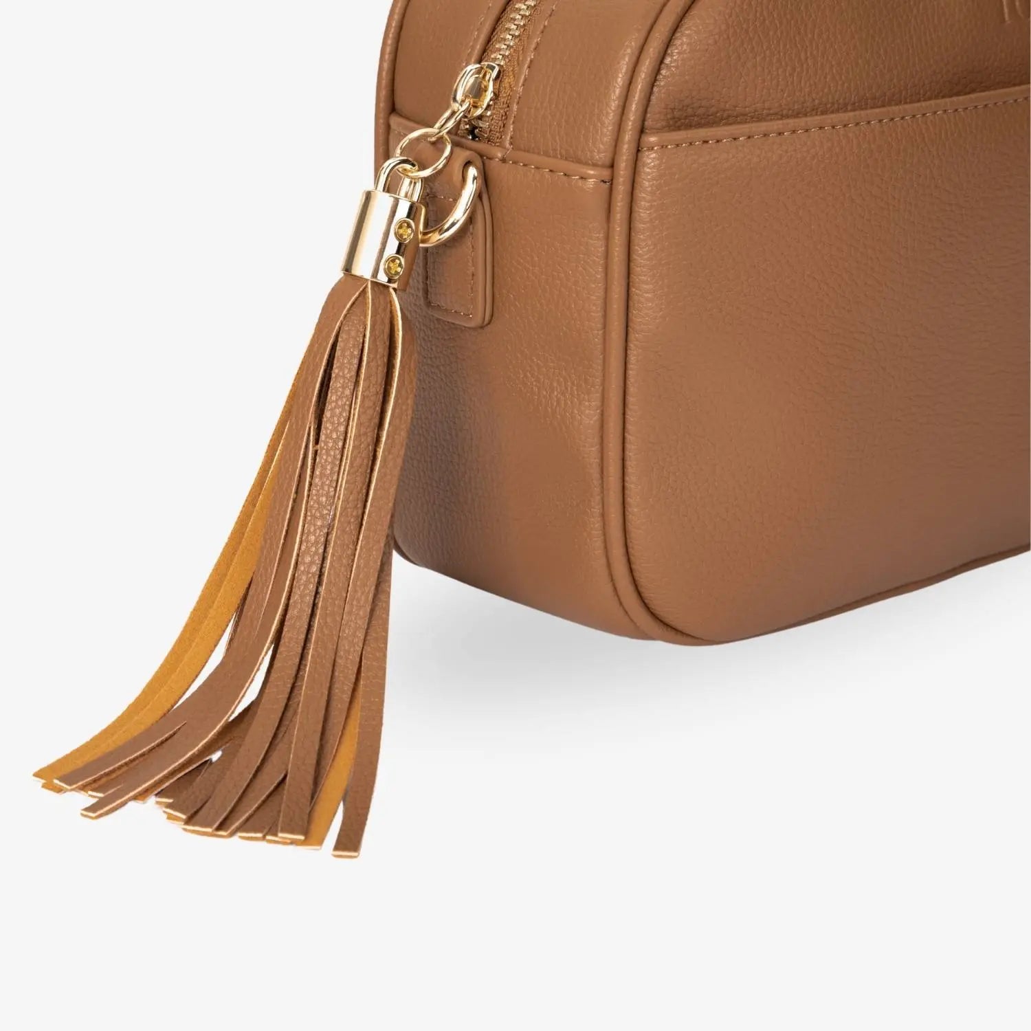 Bag tassel detail of tan colour crossbody bag accented with gold hardware