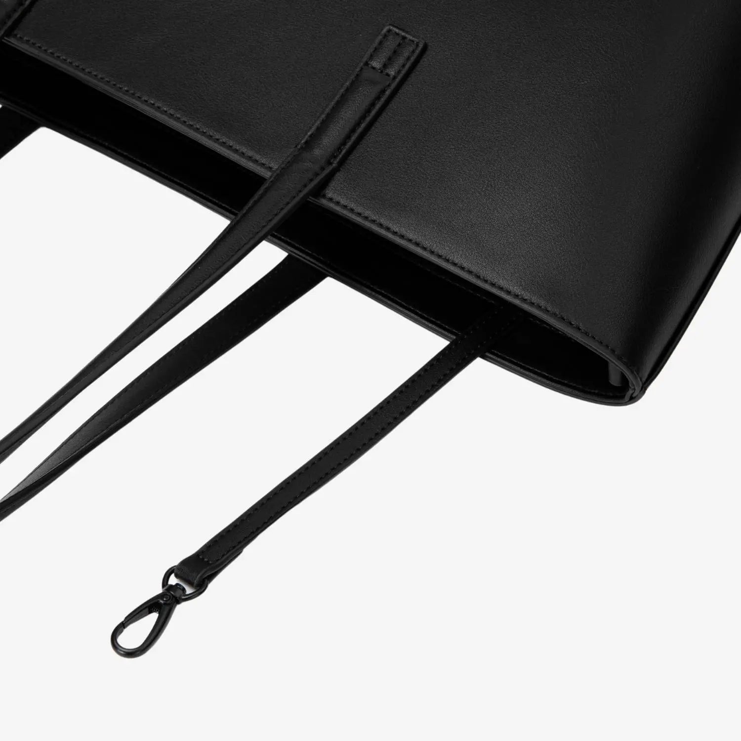Zoomed-in image of black tote bag strap focusing on sturdy construction and finish.