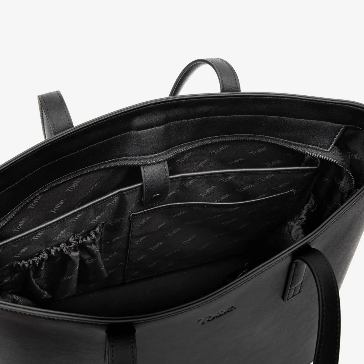 Close view inside black tote bag highlighting smooth lining and roomy interior.