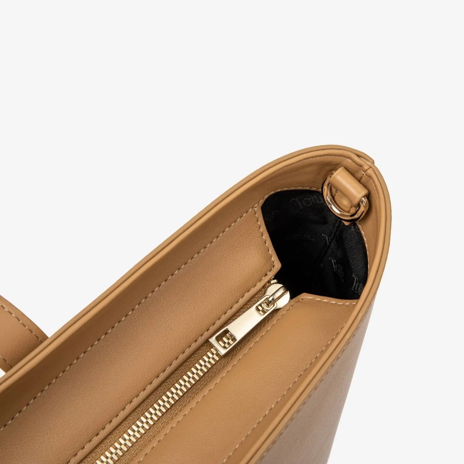 Close view of sturdy zipper on tan tote bag highlighting design and durability.