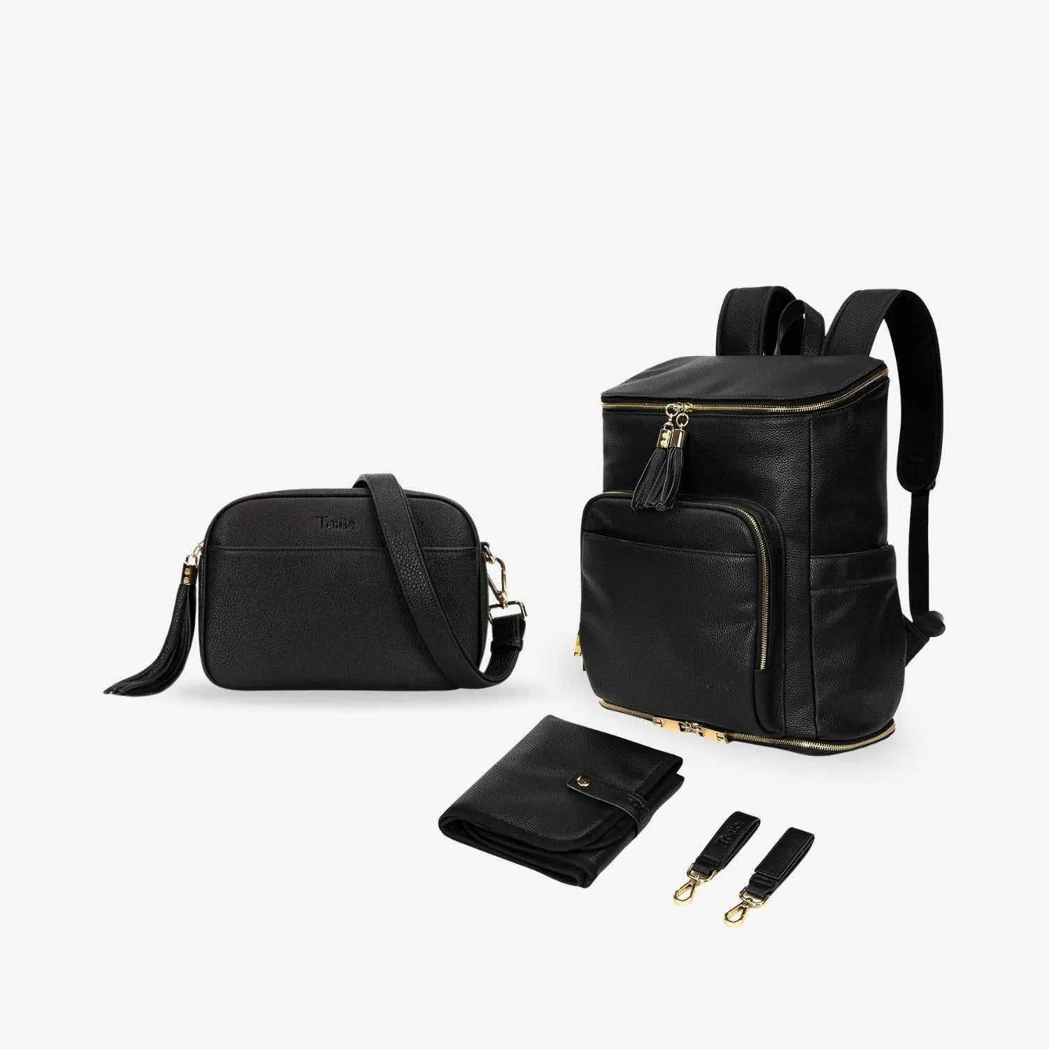 Black mama bundle with gold hardware, including nappy bag backpack, crossbody bag, baby change mat and pram clips on white background