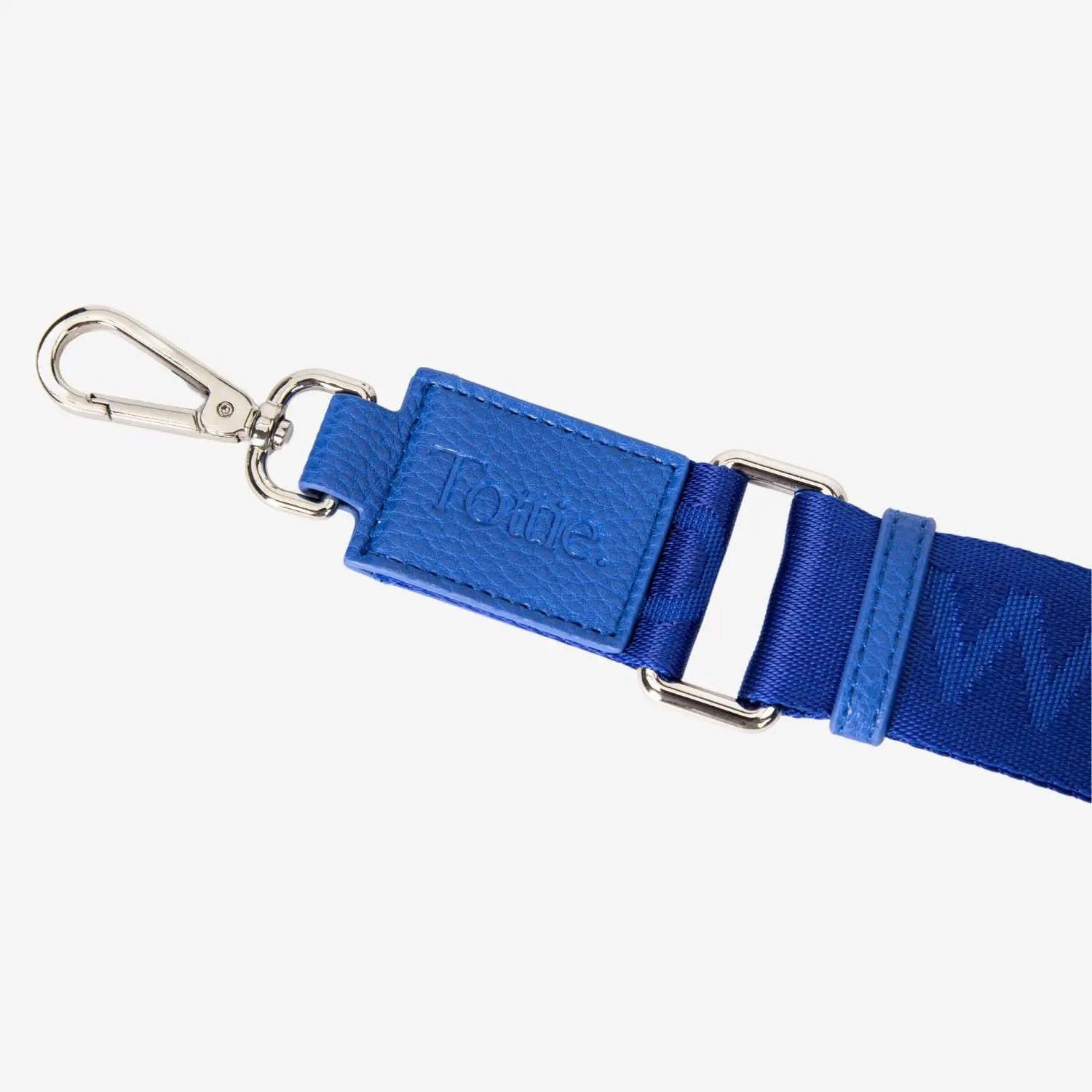 Royal blue nylon bum bag with close view of Tottie logo embossed on hardware fitting.