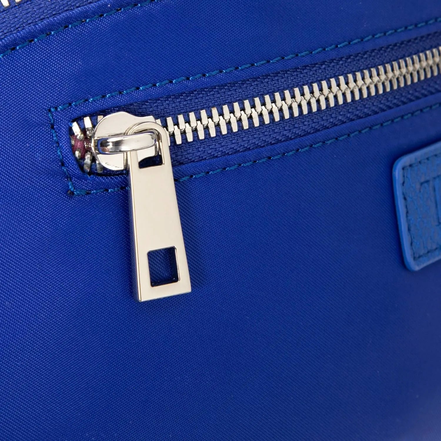 Detailed view of royal blue nylon bum bag zipper showing durable hardware.