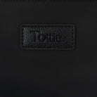 Embossed Tottie logo close-up on black nylon tote bag with cream strap, photographed on white background