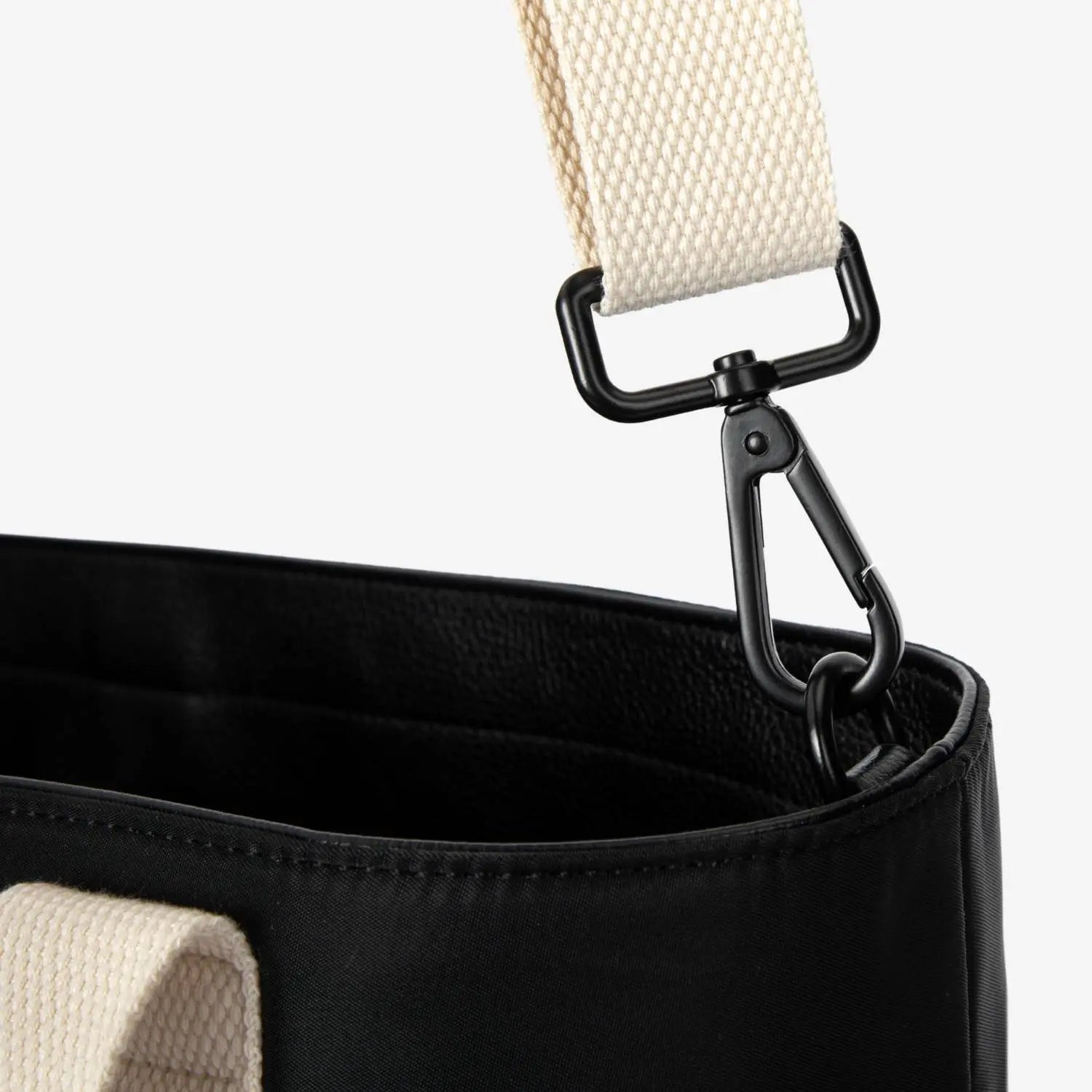 Close-up of cream strap on black nylon tote bag – durable and stylish contrast detail.