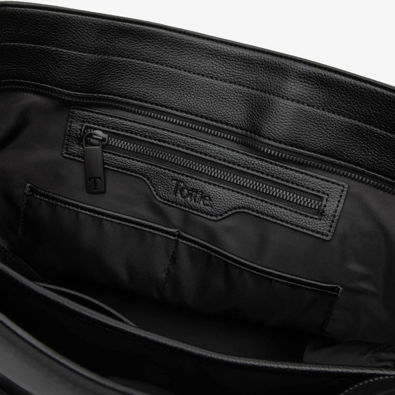 Interior view of black nylon tote bag with cream strap and embossed Tottie logo.
