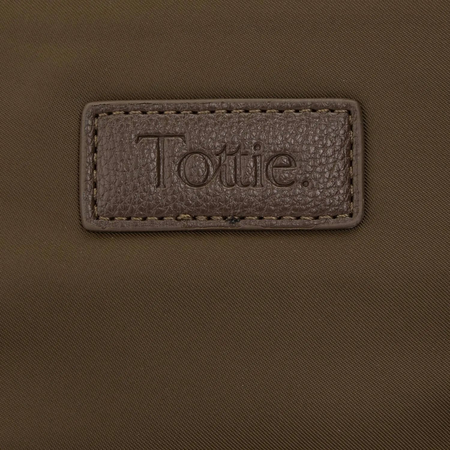Close-up of embossed Tottie logo on brown nylon tote bag, highlighting subtle branded detail.