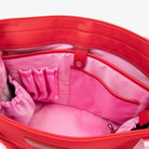 Detailed close-up of interior of red nylon tote bag showing pink strap with WDHTFT embossing on white backdrop