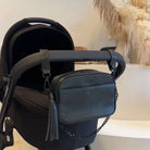 Black vegan leather pram clips and matching crossbody bag attached to a pram stroller – sleek and functional for modern mums