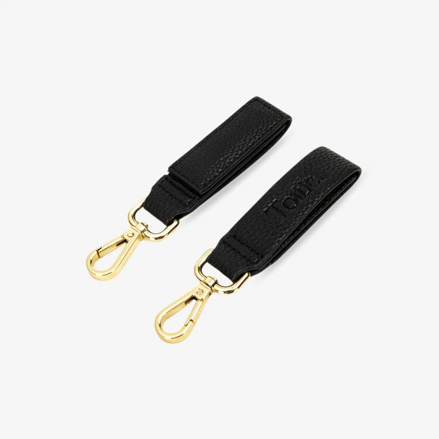 Pair of durable black pram clips with gold hardware – compact and functional design shown on white backdrop.