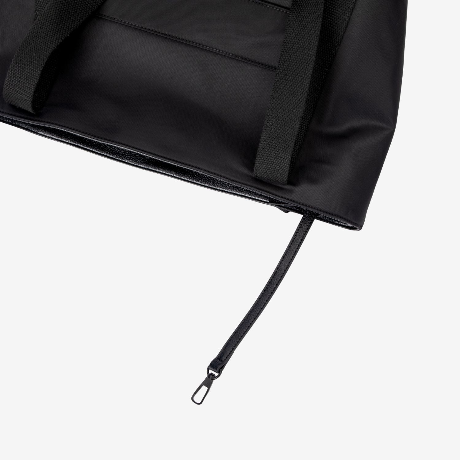Close-up of a black tote nappy bag with a zipper on a white background