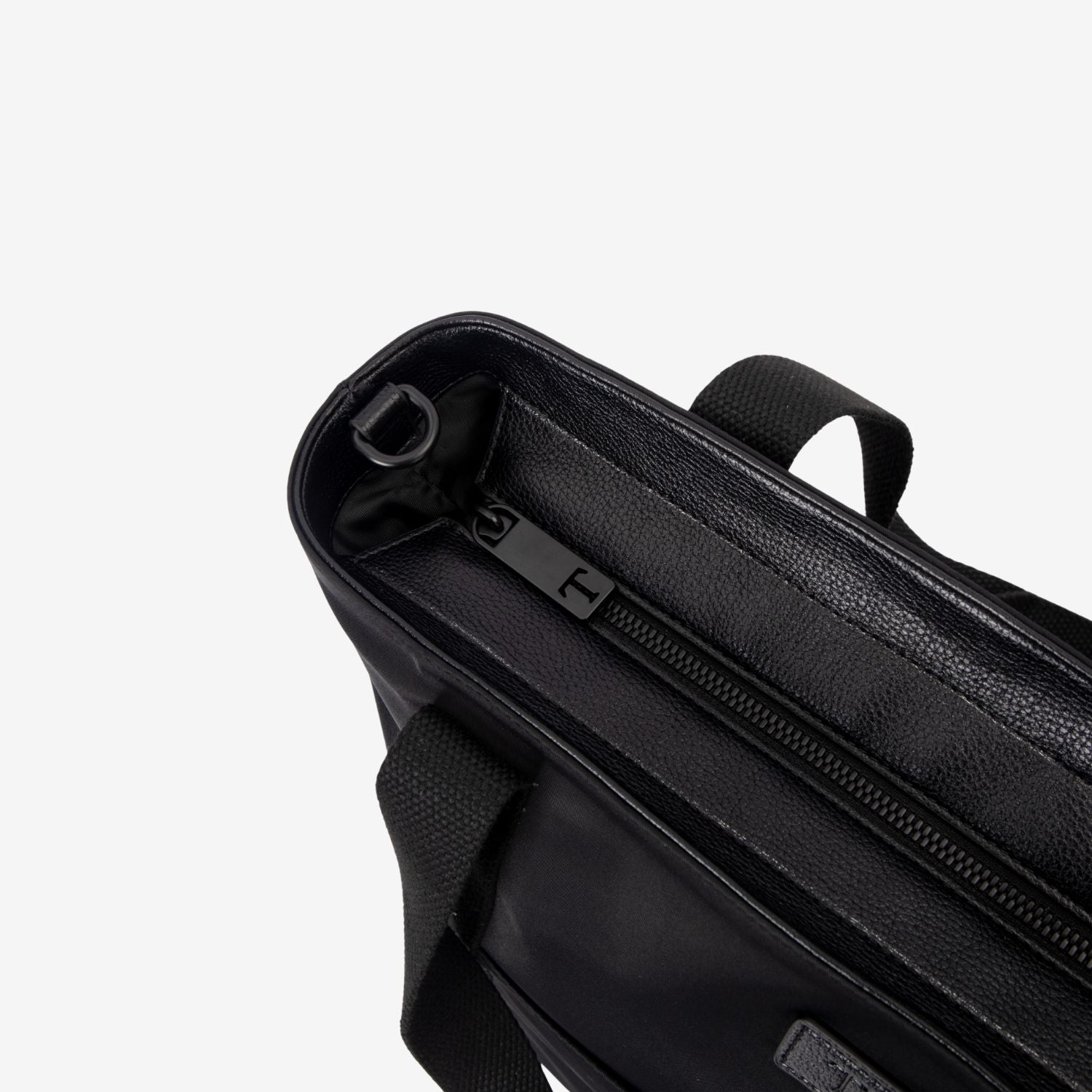Close-up of a black nylon tote bag with zipper on a white background