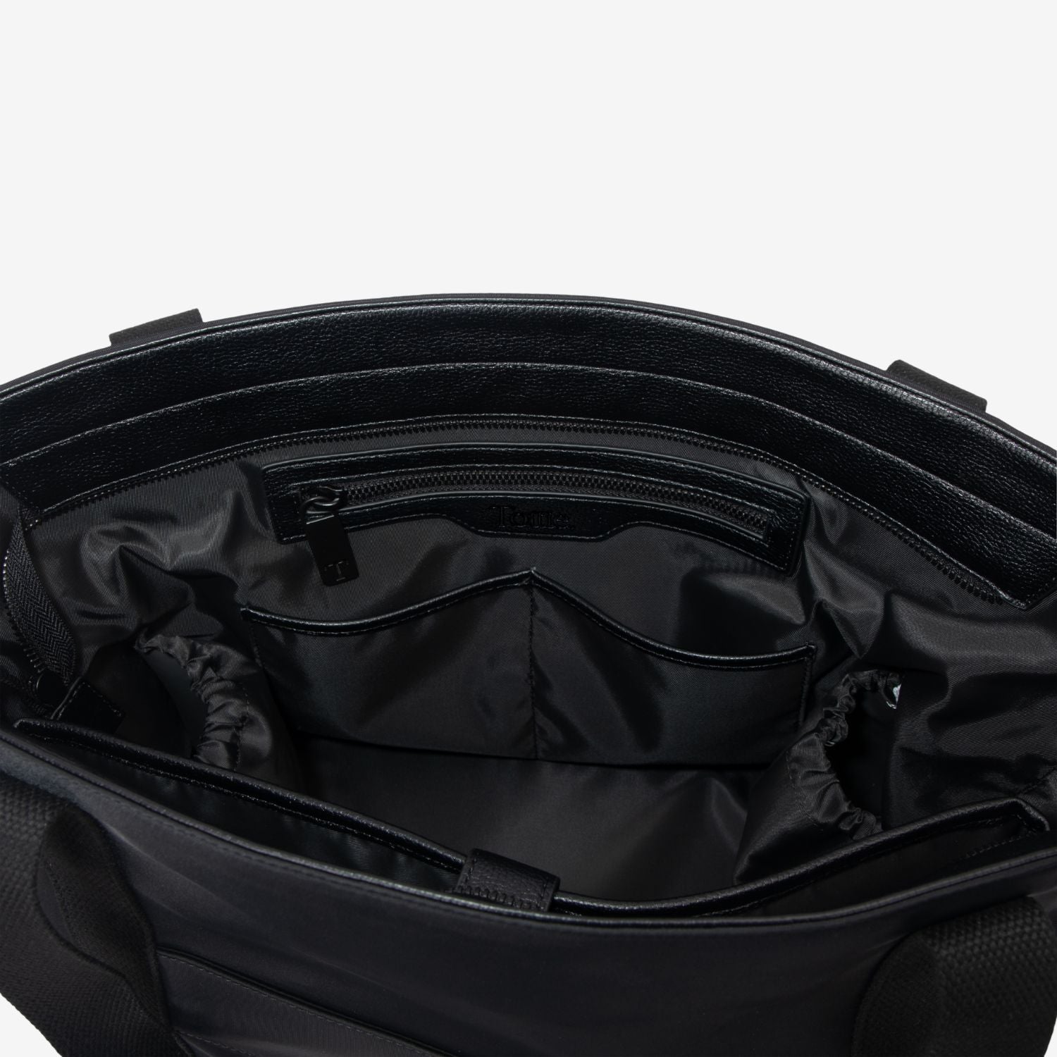 Open black nappy tote bag showing interior compartments on a white background