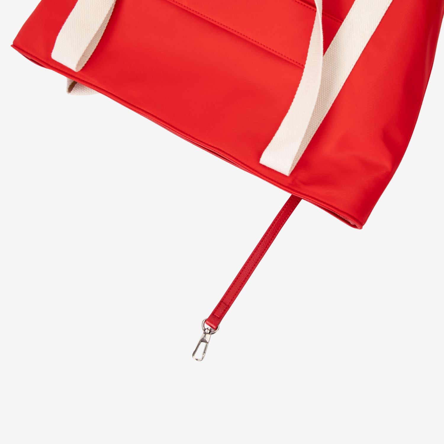 Red nylon tote bag with a white strap on a light gray background