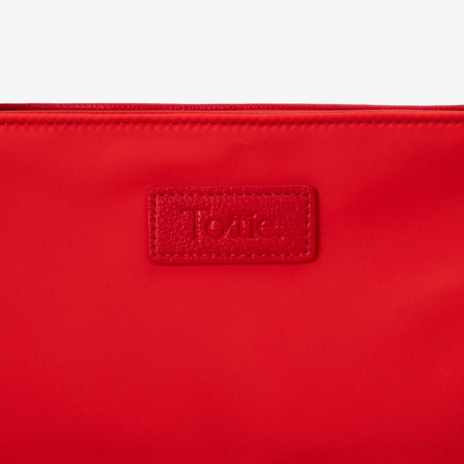 Red tote bag with a Tottie logo on a white background
