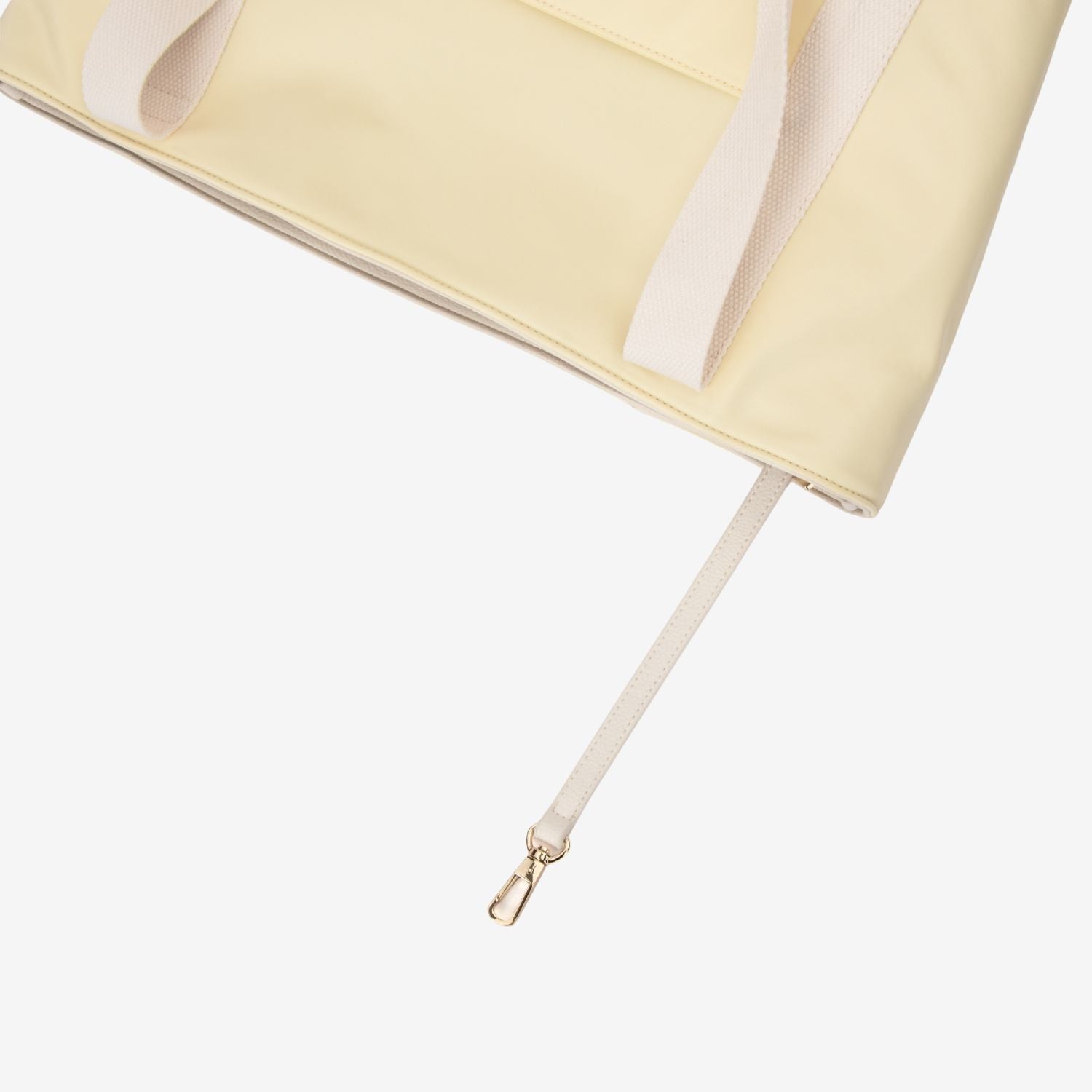 Close-up of a yellow tote bag with a key chain on a white background