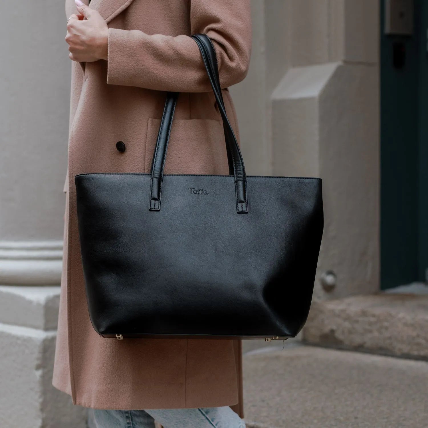 Tote bag carried on the arm of a woman wearing professional work clothes.
