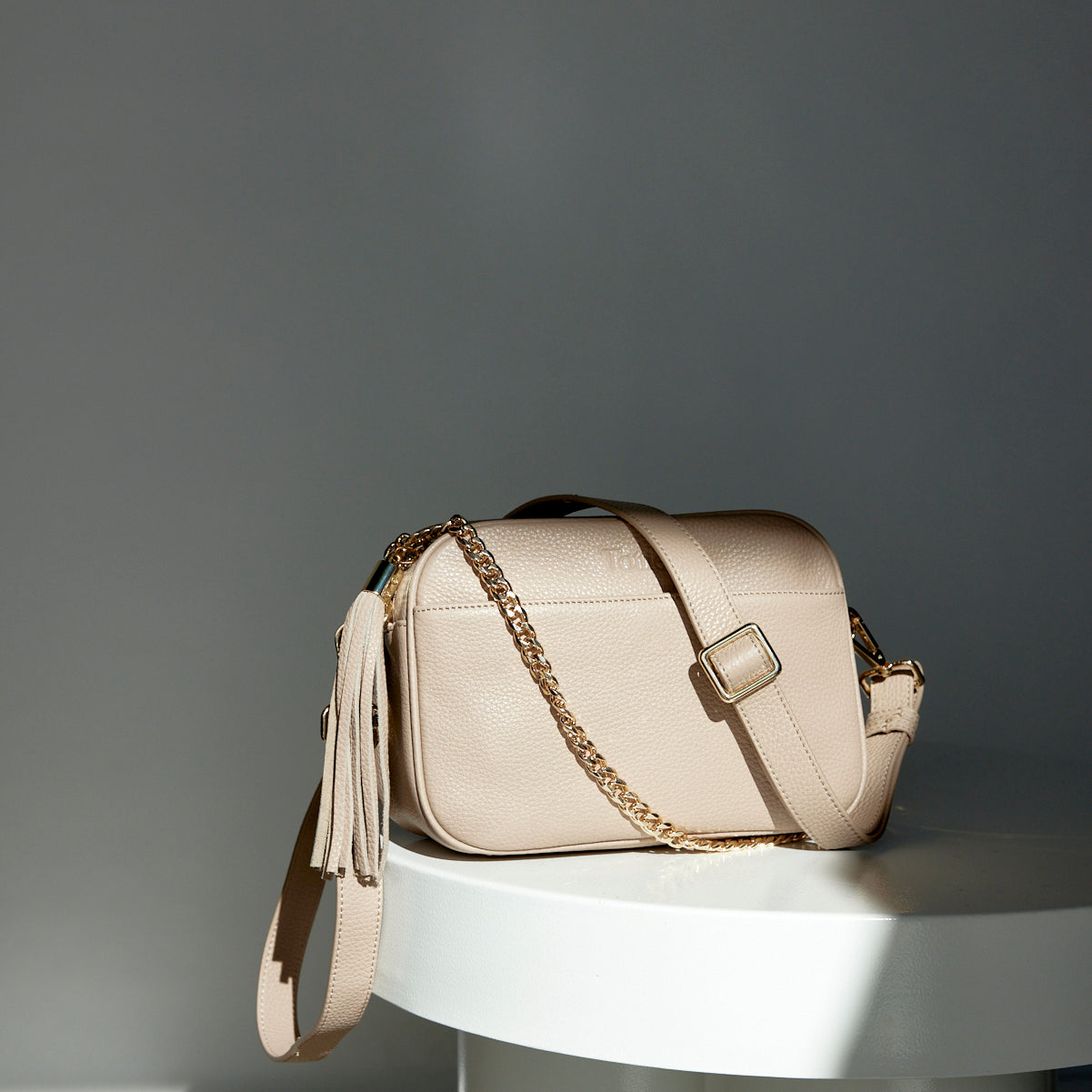 a bestie crossbody bag sitting on white table