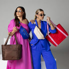 Woman in fuchsia pink with brown nylon tote bag and blue bum bag, standing next to another in royal blue outfit holding cream bum bag and red nylon tote bag with pink strap.