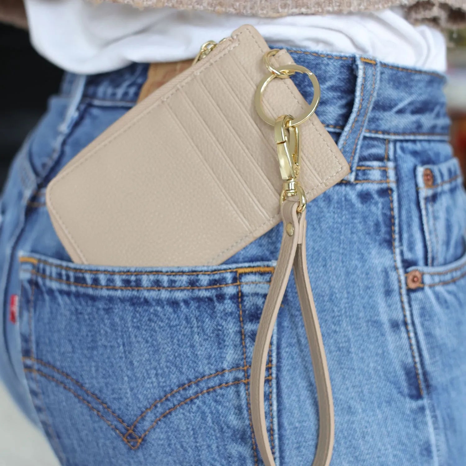 Stone card holder wallet wristlet tucked into the back pocket of jeans