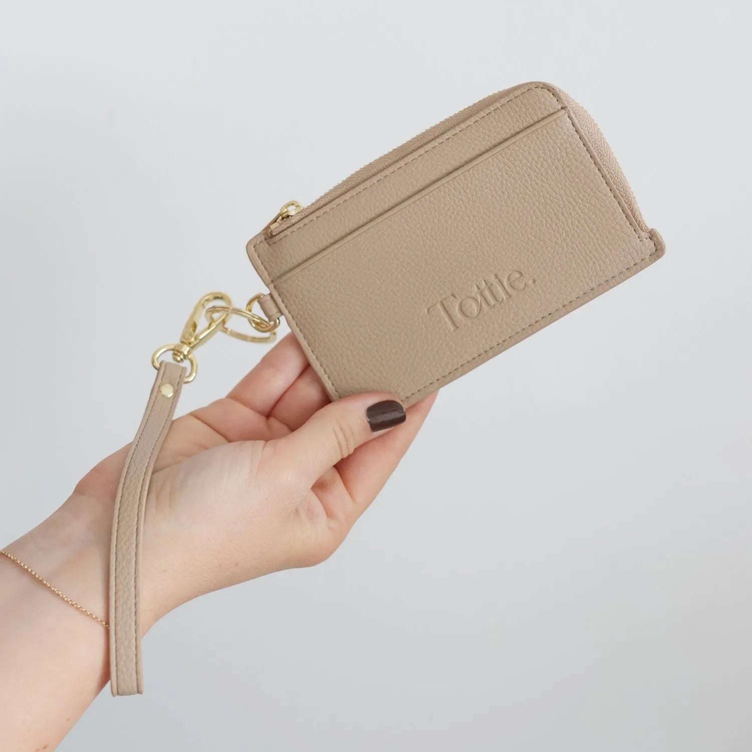 Elegant stone card holder wallet with wristlet, held in hand