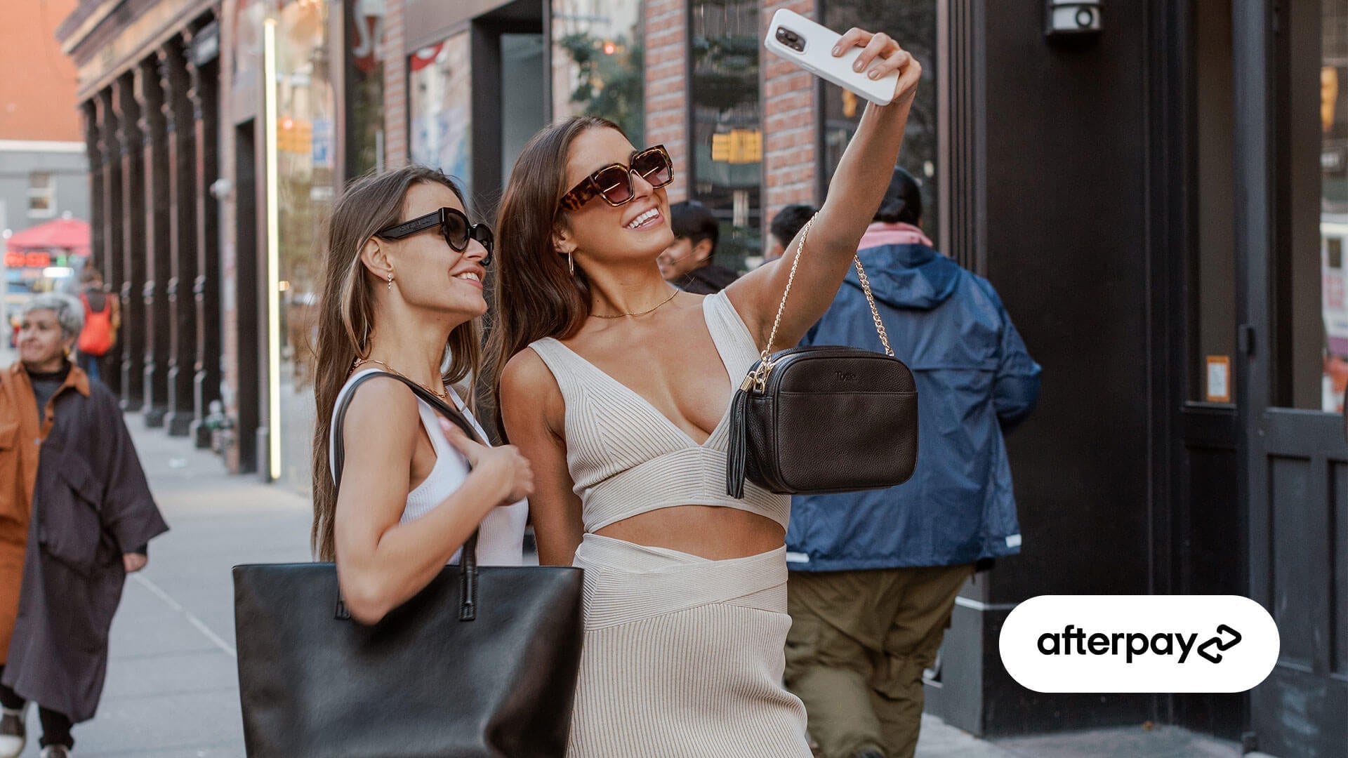 two woman taking a selfie in the street after shopping for their Tottie bags using Afterpay