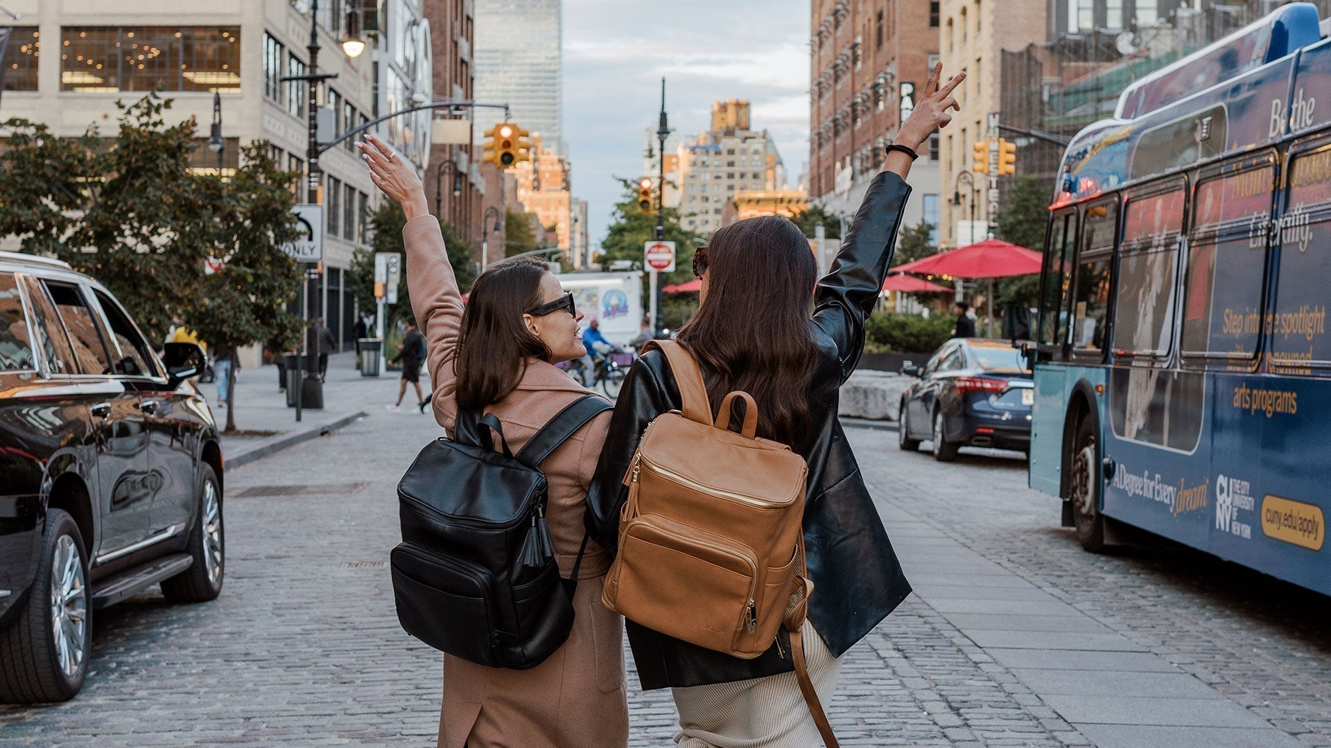 Two female tourists in New York posing happily, backpacks loaded with clever travel hacks items for convenience