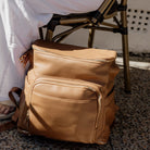 Tan leather nappy backpack on a chair at the cafe